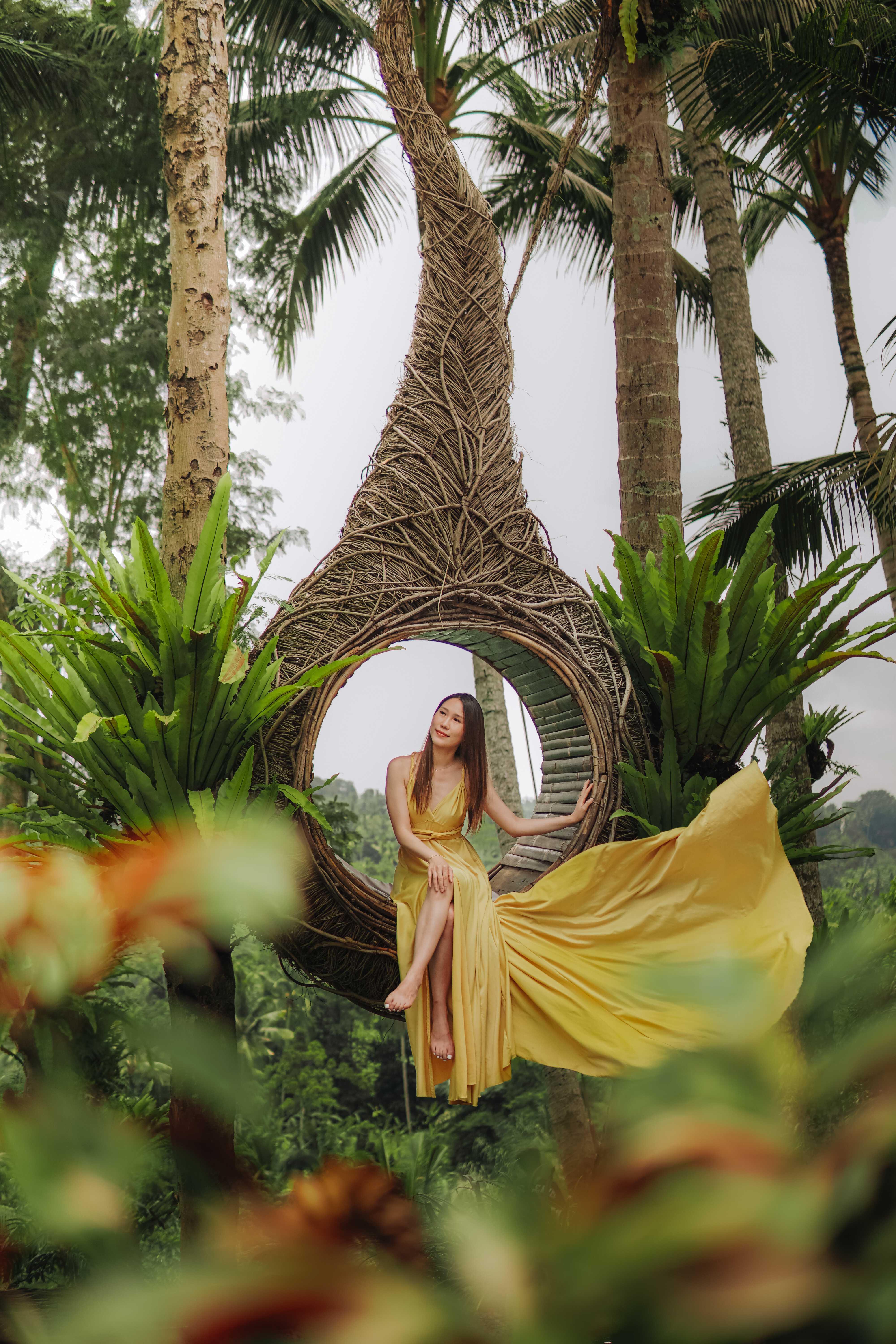 Woman on the iconic Bali Swing surrounded by tropical palms