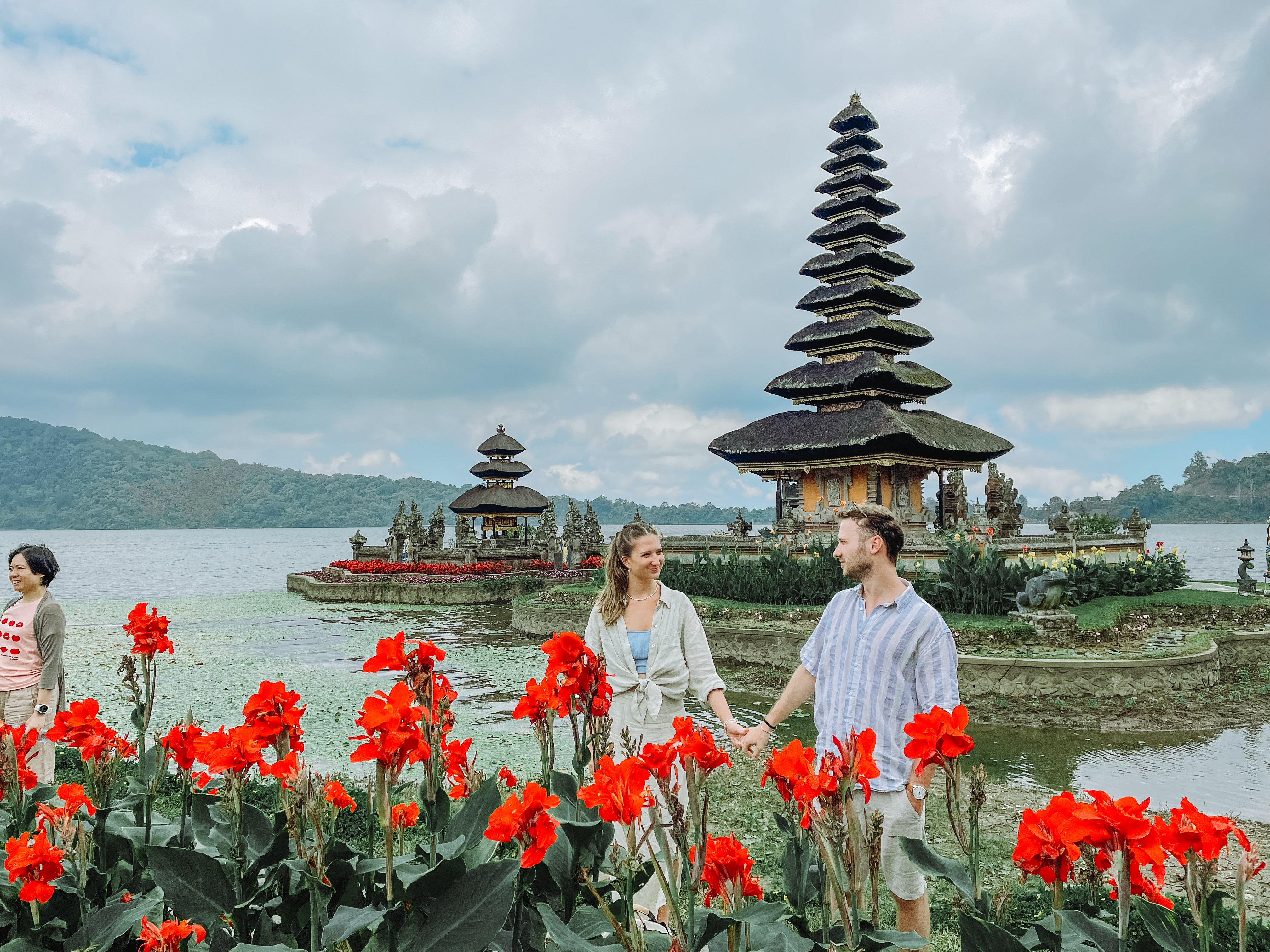 Couple at Ulun Danu Beratan Temple on Lake Beratan with red flowers